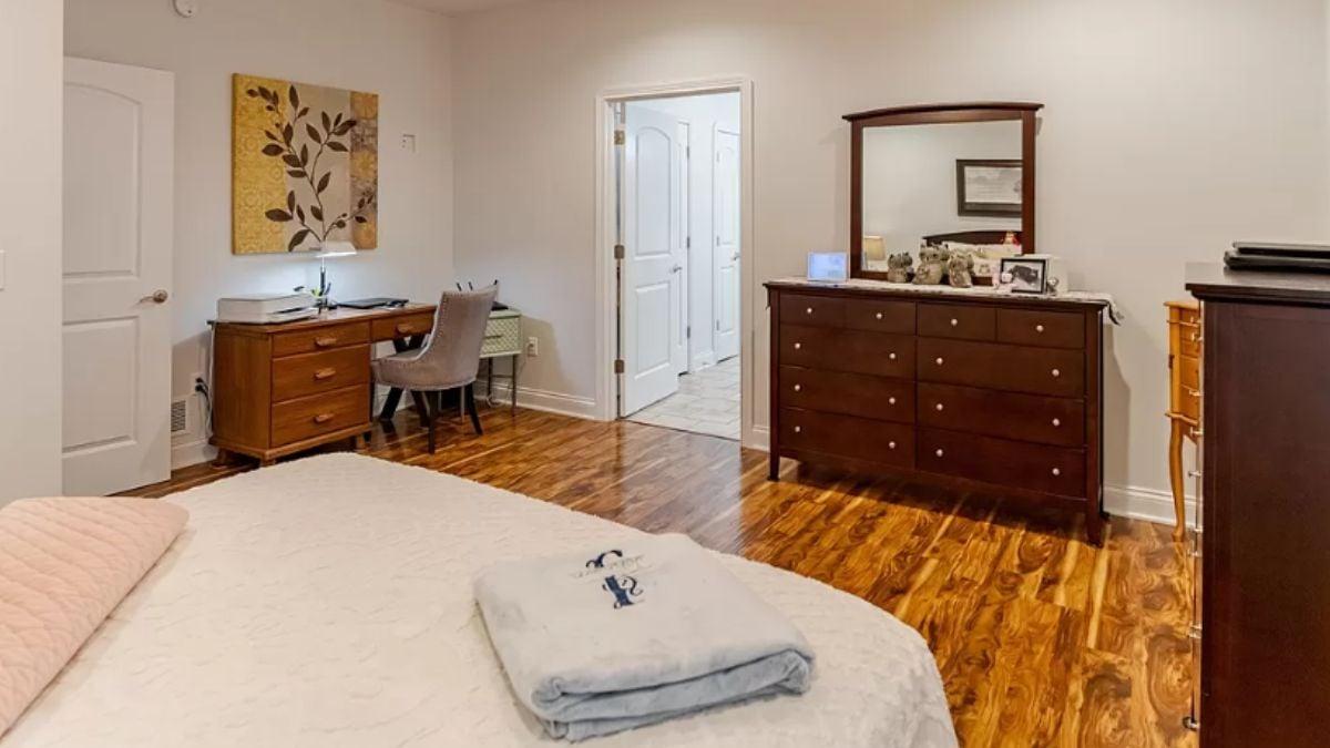 Warm Bedroom Retreat with a Writing Desk and Classic Wooden Dresser