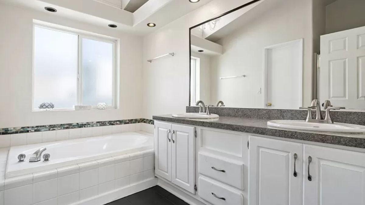 Dual Sinks in a Bright Bathroom with Subtle Mosaic Accents