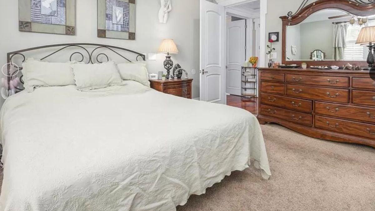 Traditional Bedroom with Ornate Wooden Dresser and Iron Bed Frame