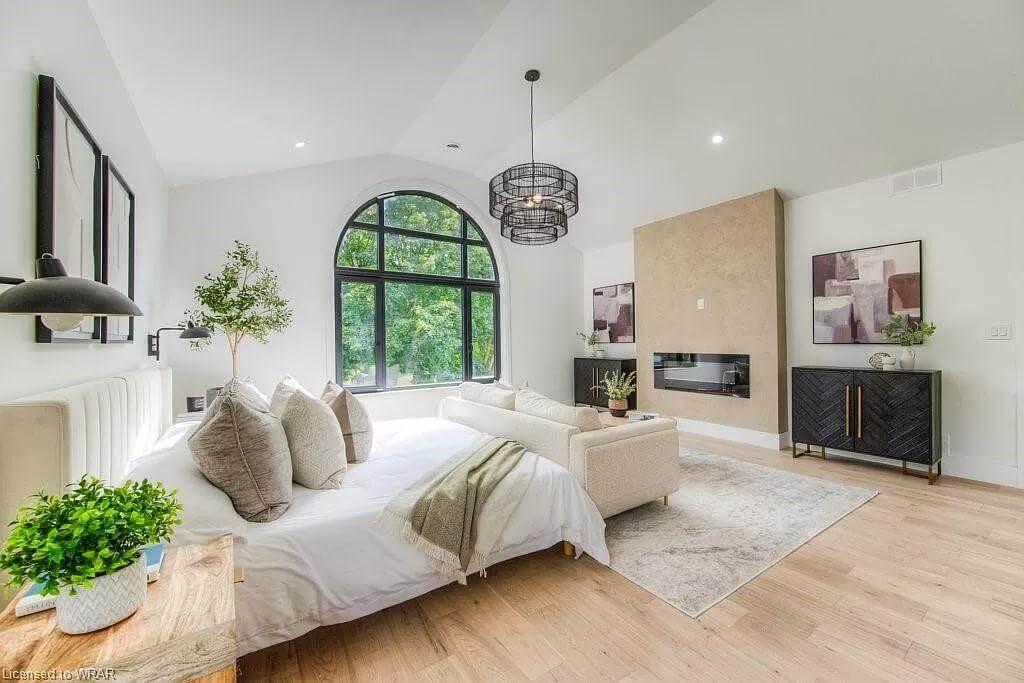 Spacious Bedroom with Striking Arched Window and Modern Fireplace