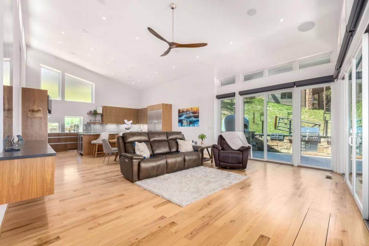 Open Living Space with Expansive Windows and Chic Ceiling Fan