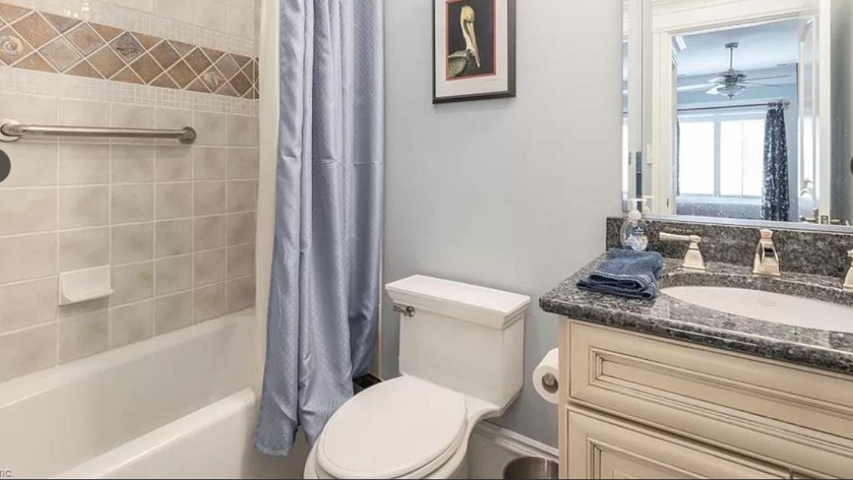 Compact Bathroom Featuring a Granite Vanity and Soft Blue Accents