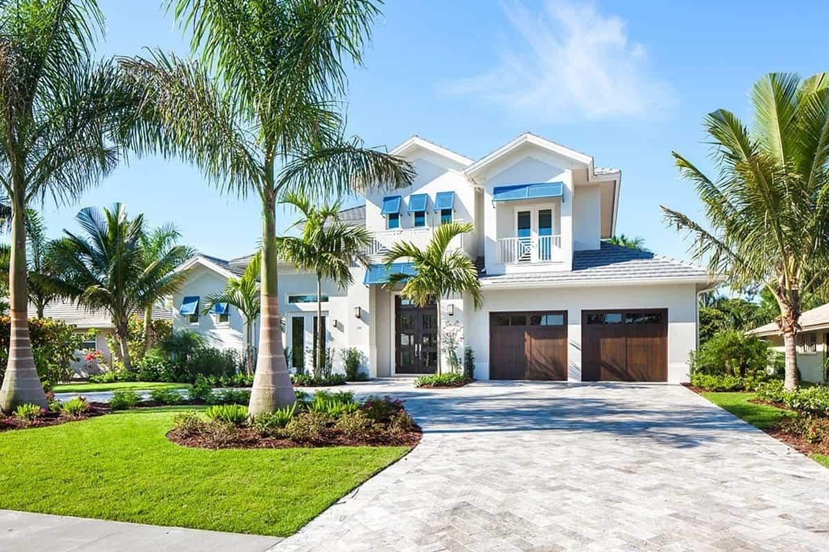 Tropical Oasis with Striking Blue Accents and Palm-Lined Driveway