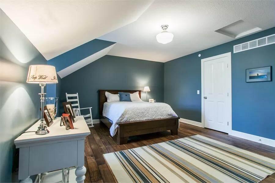 Cozy Attic Bedroom with Sloped Ceilings and Deep Blue Walls
