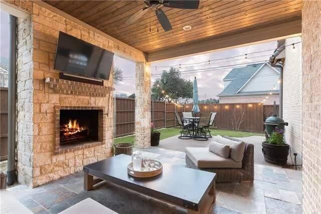 Outdoor Living Space with a Cozy Stone Fireplace and String Lights