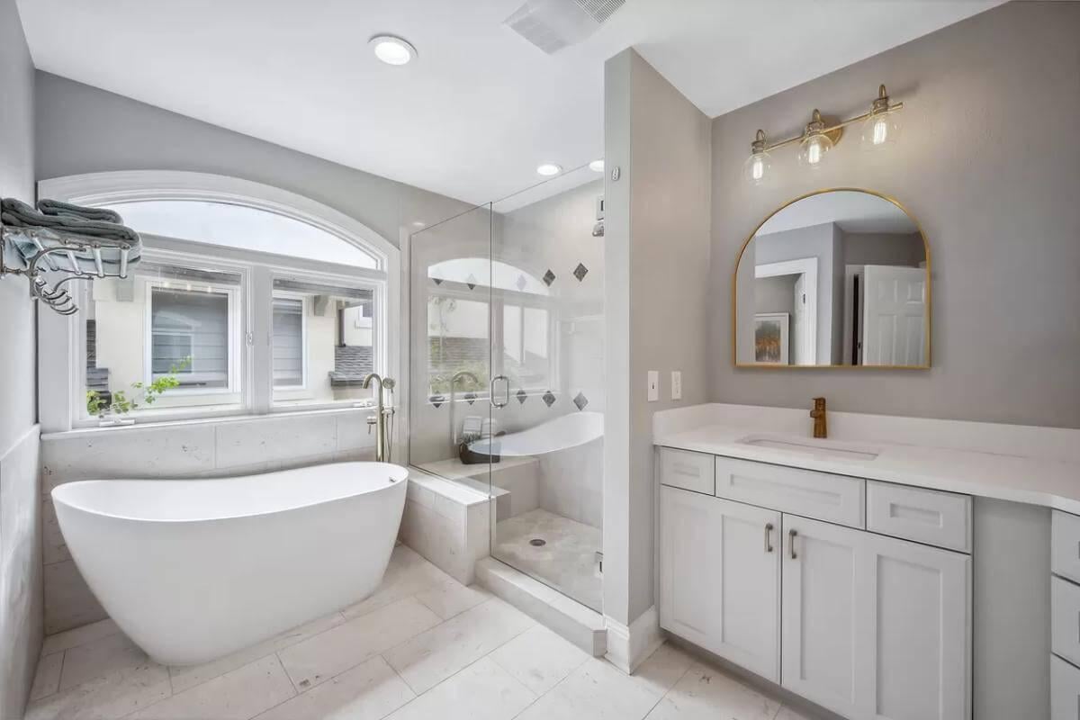 Relax in This Spa-Like Bathroom with Freestanding Tub and Arched Window