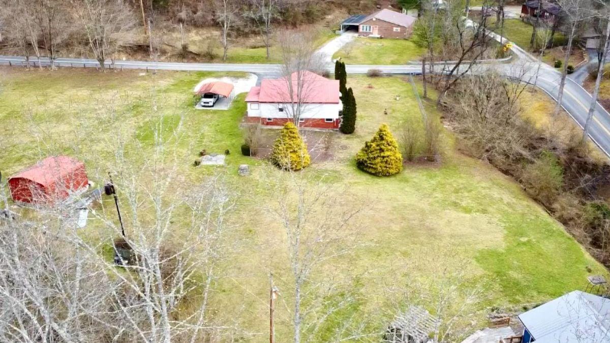 Expansive Yard with Rolling Views and a Distinctive Red Roof