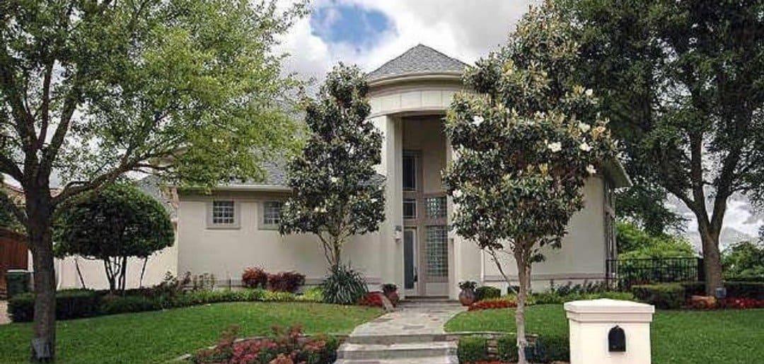 Grand Entrance with Towering Columns and Lush Landscaping