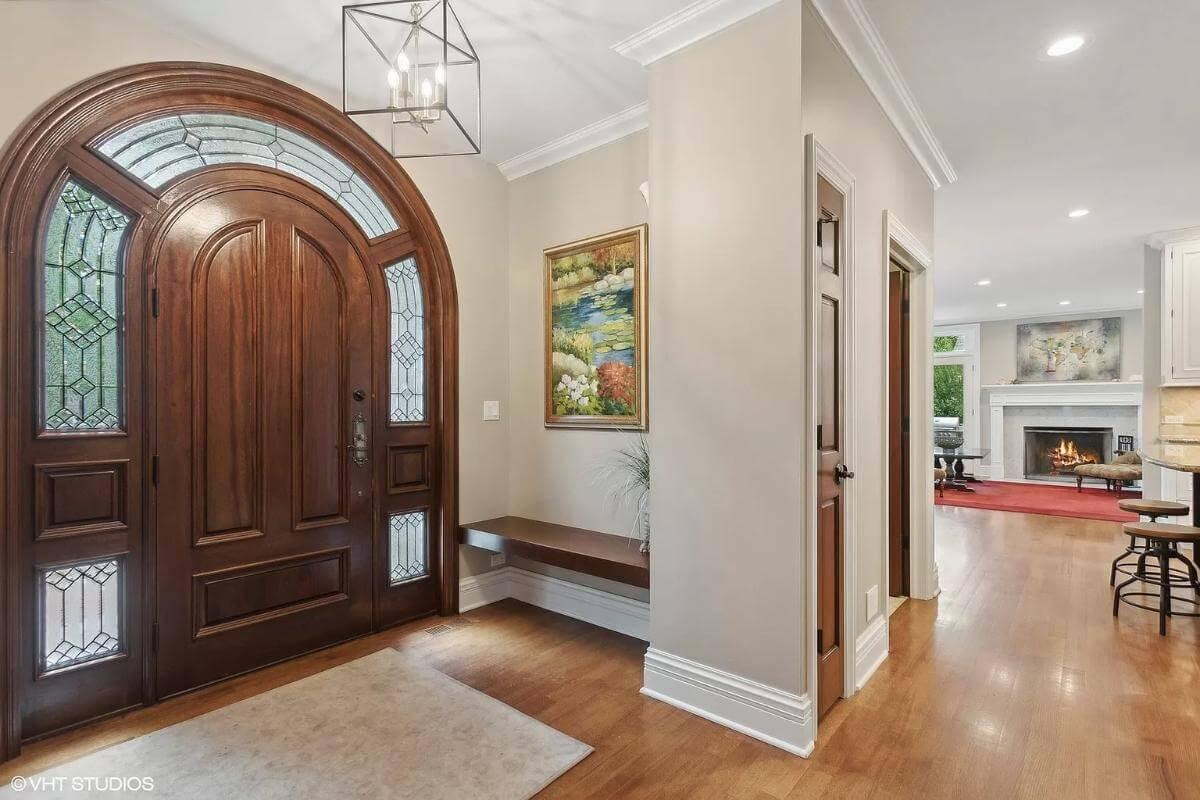 Stunning Entryway with Arched Wood Door and Details That Draw You In