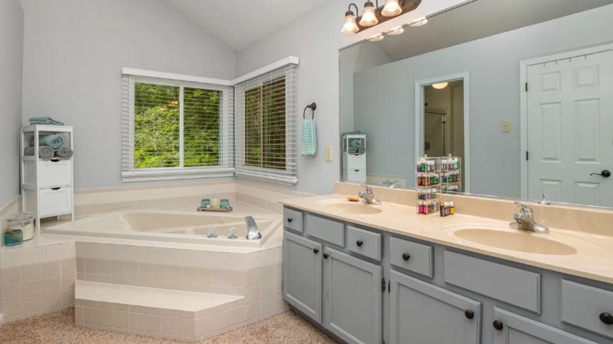 Explore the Double Vanity and Corner Tub in This Spacious Bathroom