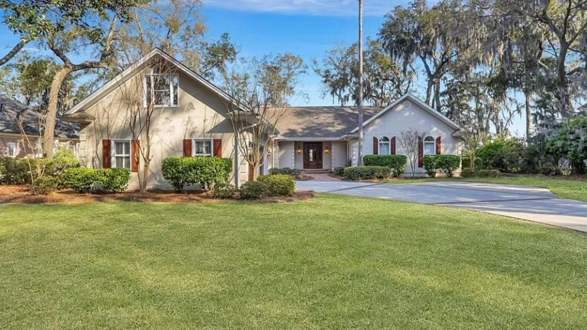 Charming Facade Enhanced by Shuttered Windows and Tree-Lined Driveway
