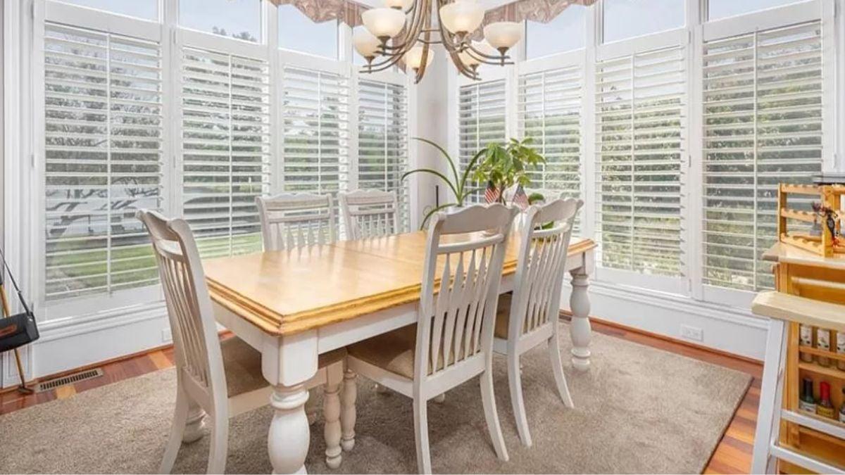 Bright Dining Area With a Bay of Windows and Charming Shutters