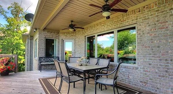 Spacious Patio with Ceiling Fans and Cozy Brick Details