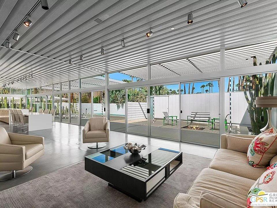 Open Concept Living Space with Expansive Glass Walls Featuring Palm Views