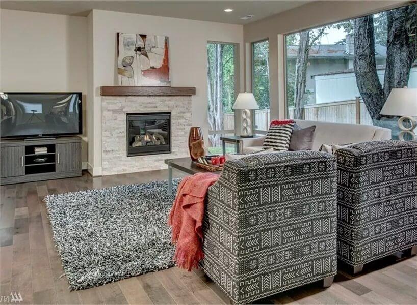 Cozy Living Room with Patterned Armchairs and a Modern Fireplace