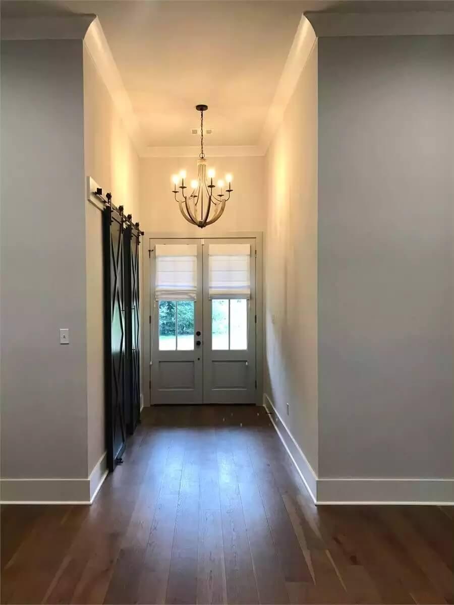 Elegant Entryway Featuring Barn Doors and a Statement Chandelier