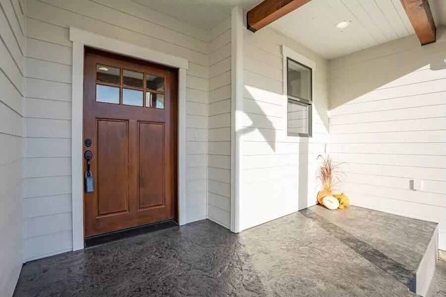 Craftsman Entryway with Elegant Wooden Door and Stone-Look Porch