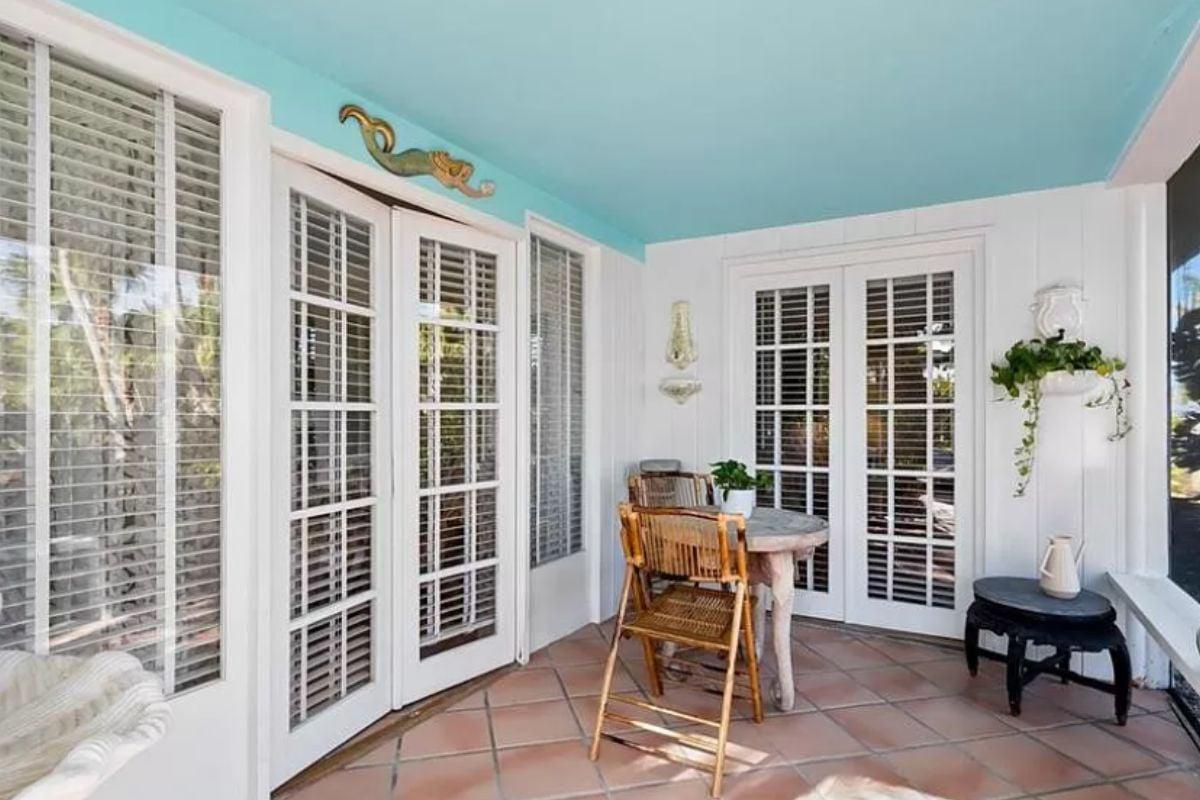 Admire the Playful Ceiling Color in This Charming Sunroom