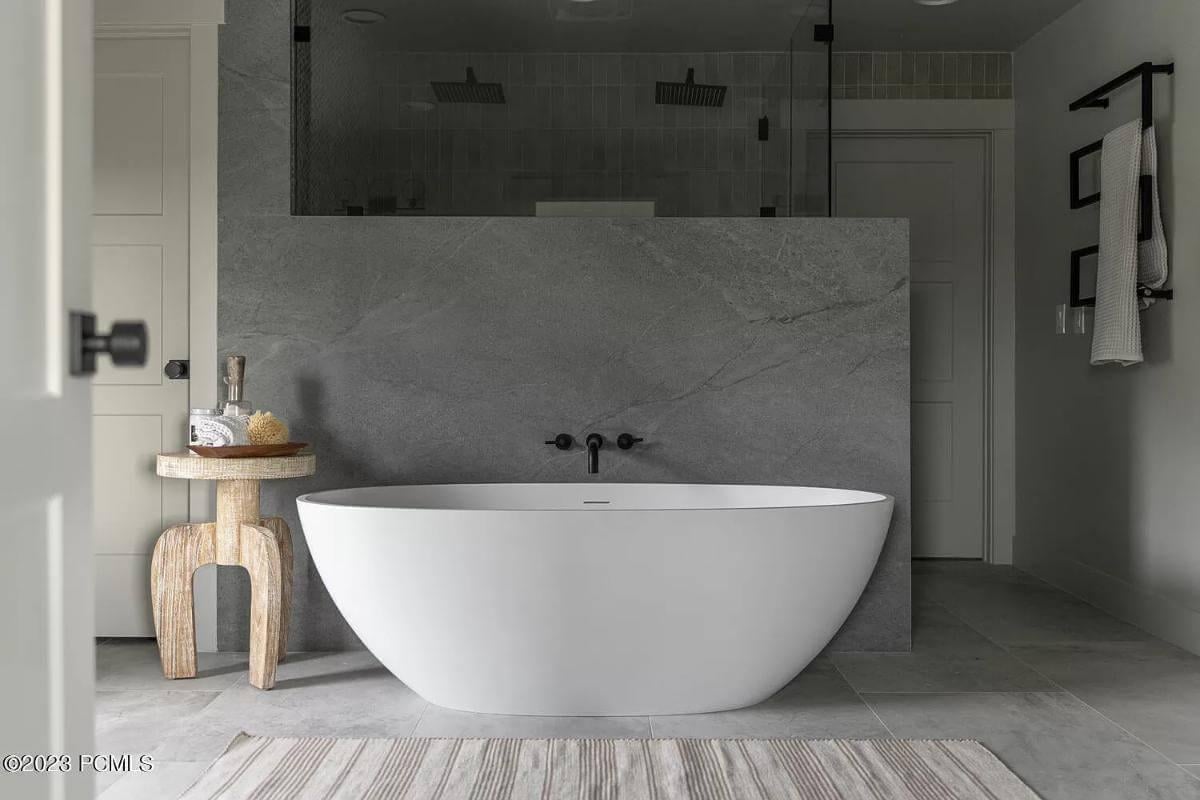 Minimalist Bathroom with Freestanding Tub and Stone Accent Wall