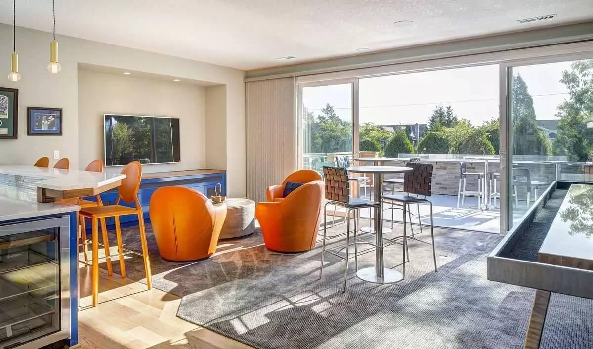 Bold Orange Accents in a Sunlit Lounge Area With Outdoor Access