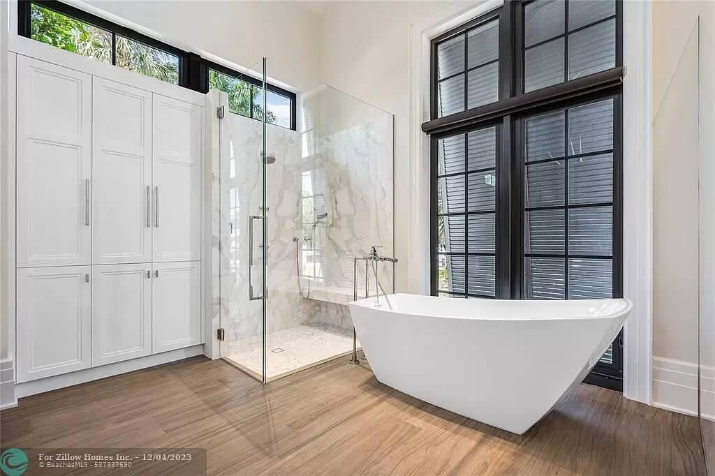 Sleek Bathroom Oasis with a Freestanding Tub and Glass-Panel Shower