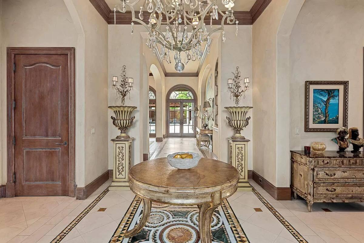 Opulent Entryway with Intricate Tiled Flooring and Crystal Chandelier