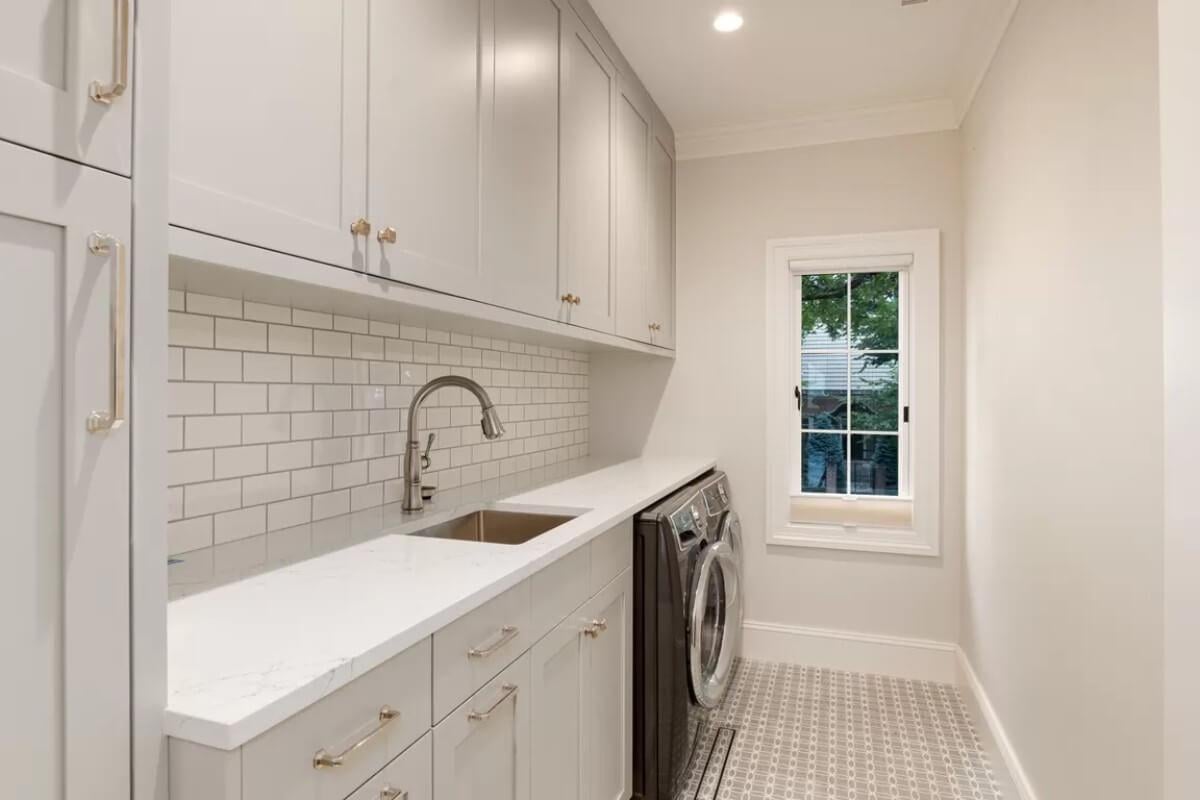 Look at This Streamlined Laundry Room With Subway Tile and Ample Storage