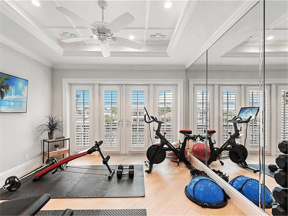 Home Gym with Mirrored Walls and Plantation Shutters Stands Out