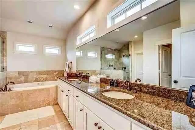 Spacious Bathroom with Granite Countertops and Natural Light
