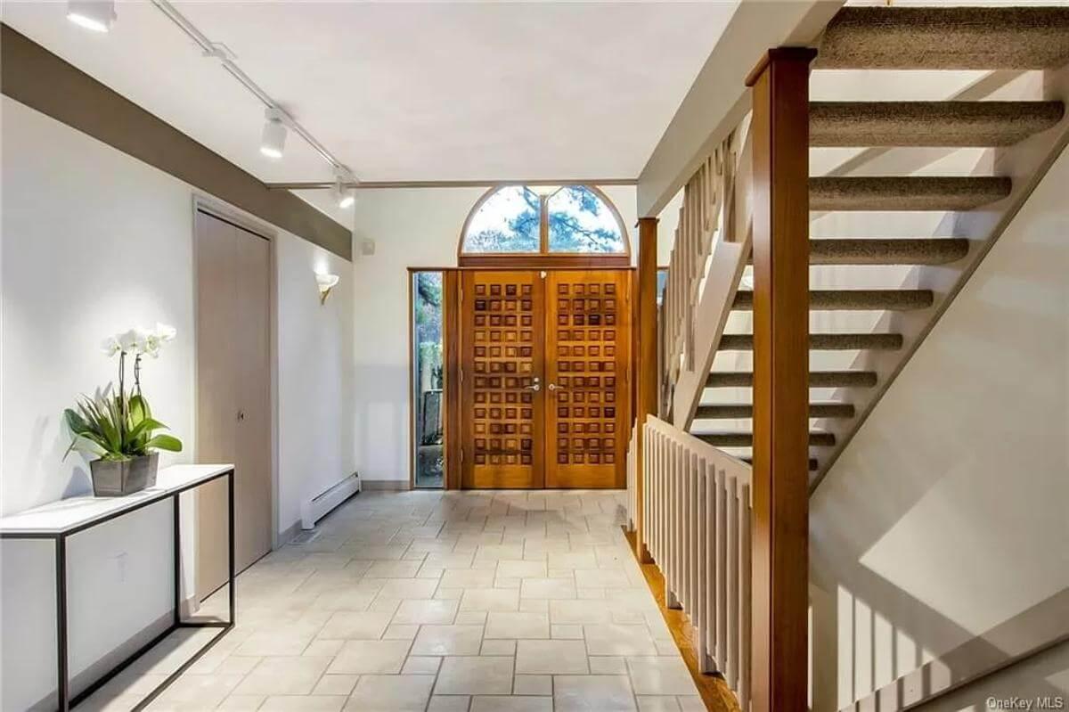Impressive Entryway with Geometric Wooden Doors and Sleek Tiles