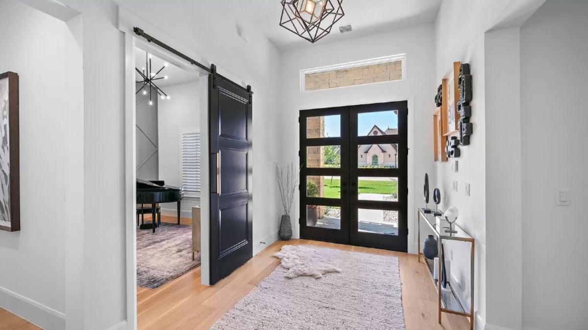 Striking Entry with Elegant Black Sliding Barn Door โ Notice the Geometric Chandelier
