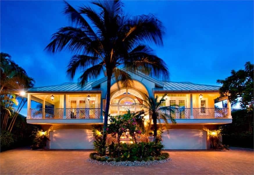 Tropical Elegance with a Grand Entryway and Lush Landscaping