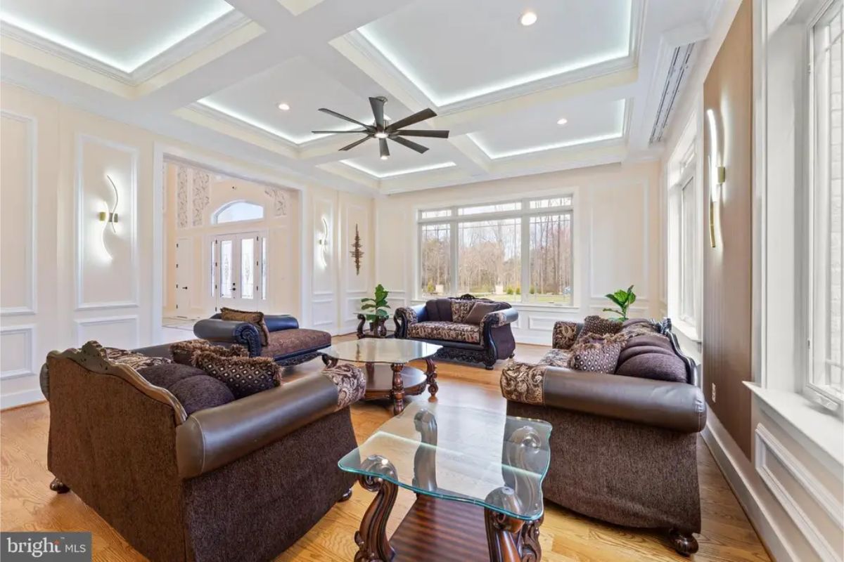  Living room with coffered ceiling, recessed lighting, and three upholstered seating sets. 
