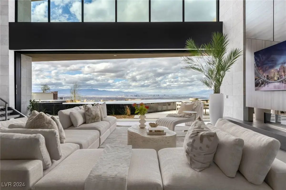 Living room with full-height retractable glass wall showcasing mountain and valley views.