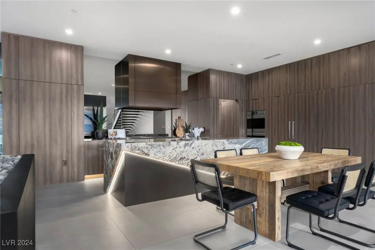 Alternate kitchen view showing built-in appliances and contrast cabinetry with vertical grain.