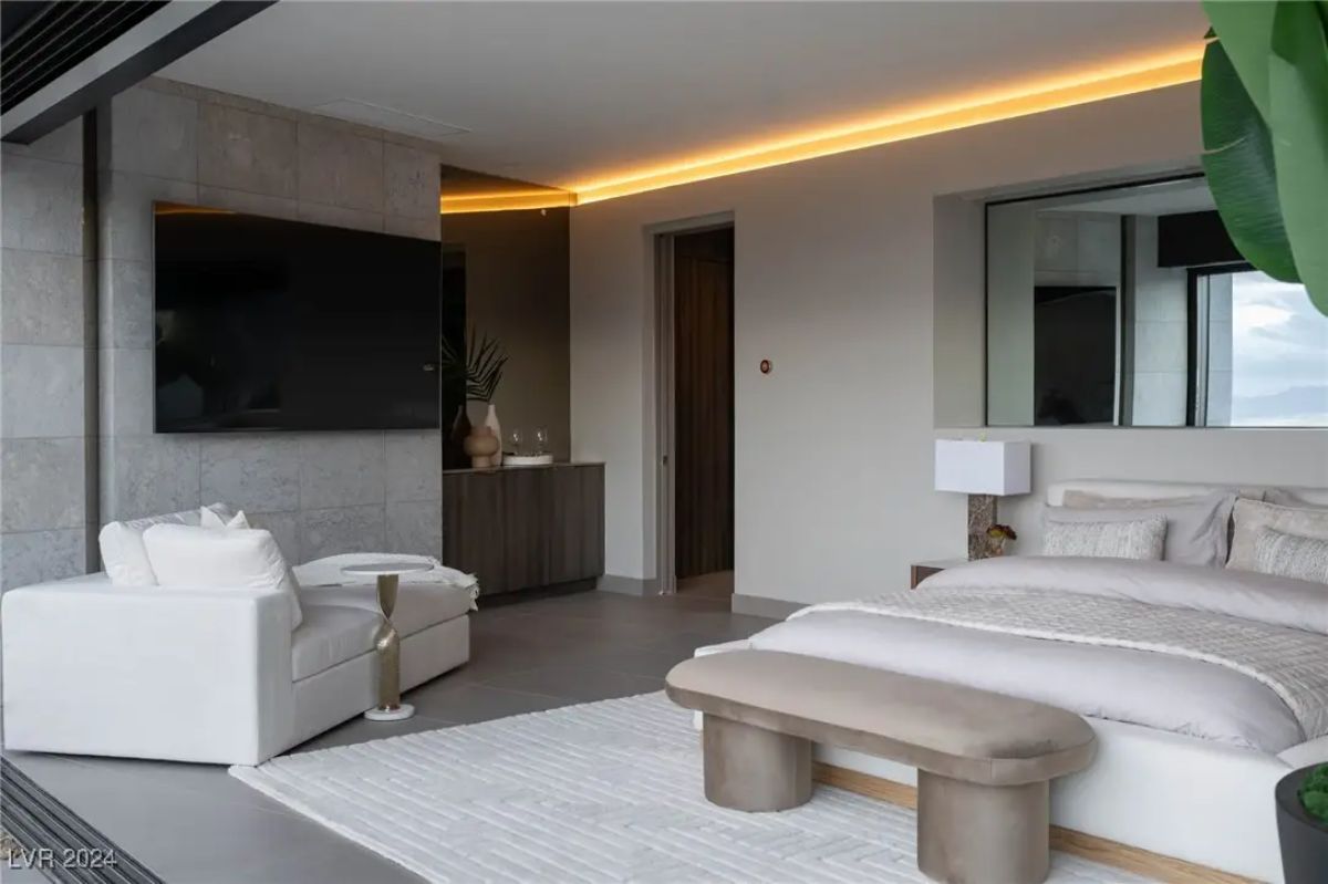 Bedroom with open-air access, neutral tones, floating vanity, and integrated LED ceiling lighting.
