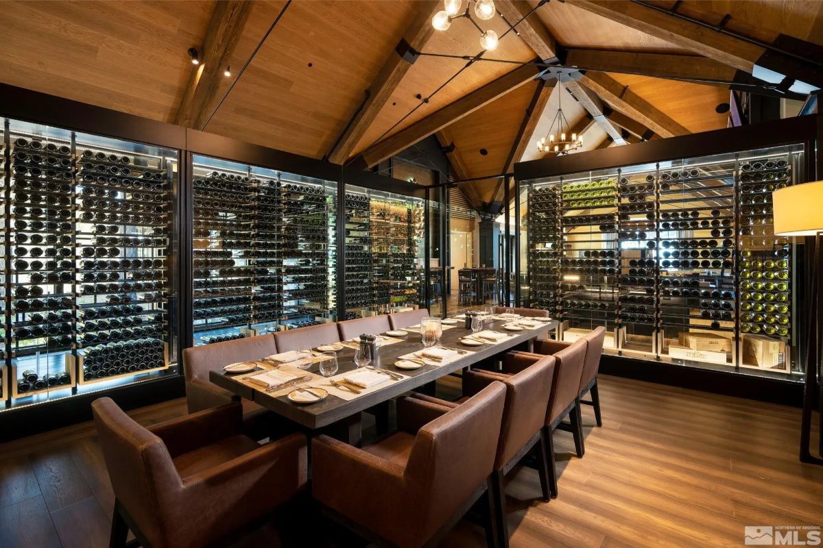 Wine cellar dining room with vaulted ceiling, leather seating, and floor-to-ceiling wine racks. 