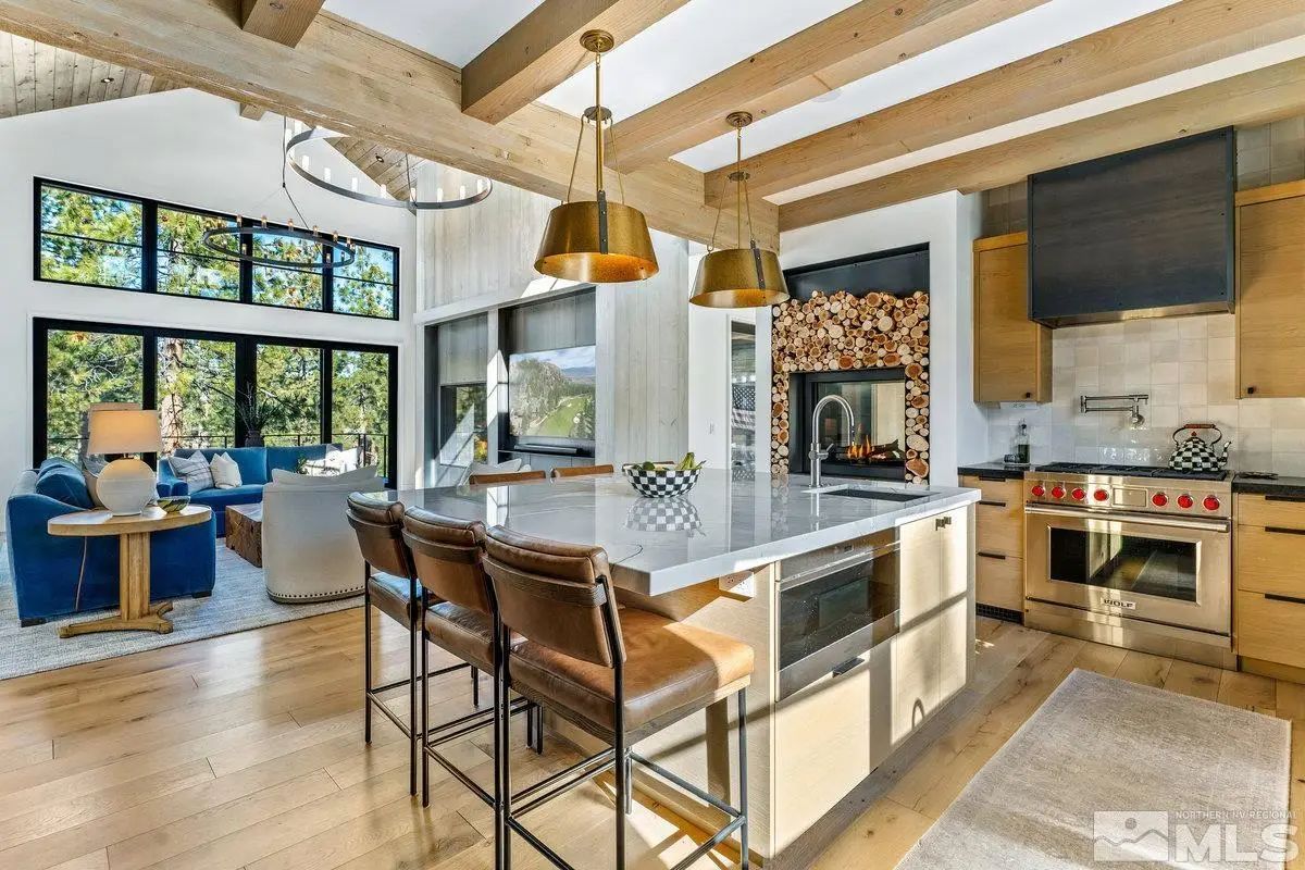 View from kitchen into living area showing open layout and exposed ceiling beams. 