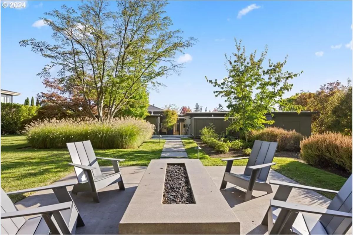 Firepit lounge with Adirondack chairs set along a garden path. 