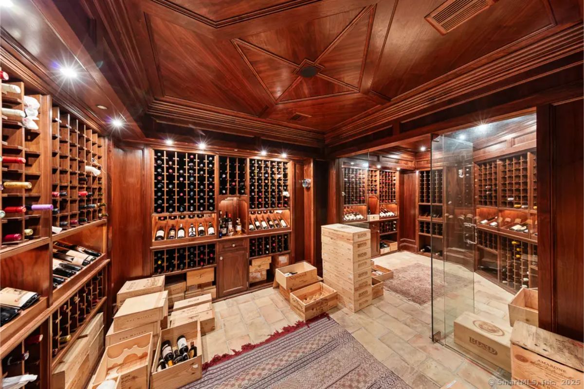 Wood-paneled wine cellar with custom racking, recessed lighting, and storage crates. 