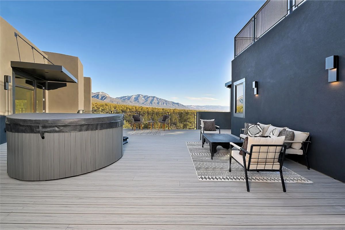 Rooftop deck with hot tub, outdoor seating, and panoramic mountain views. 