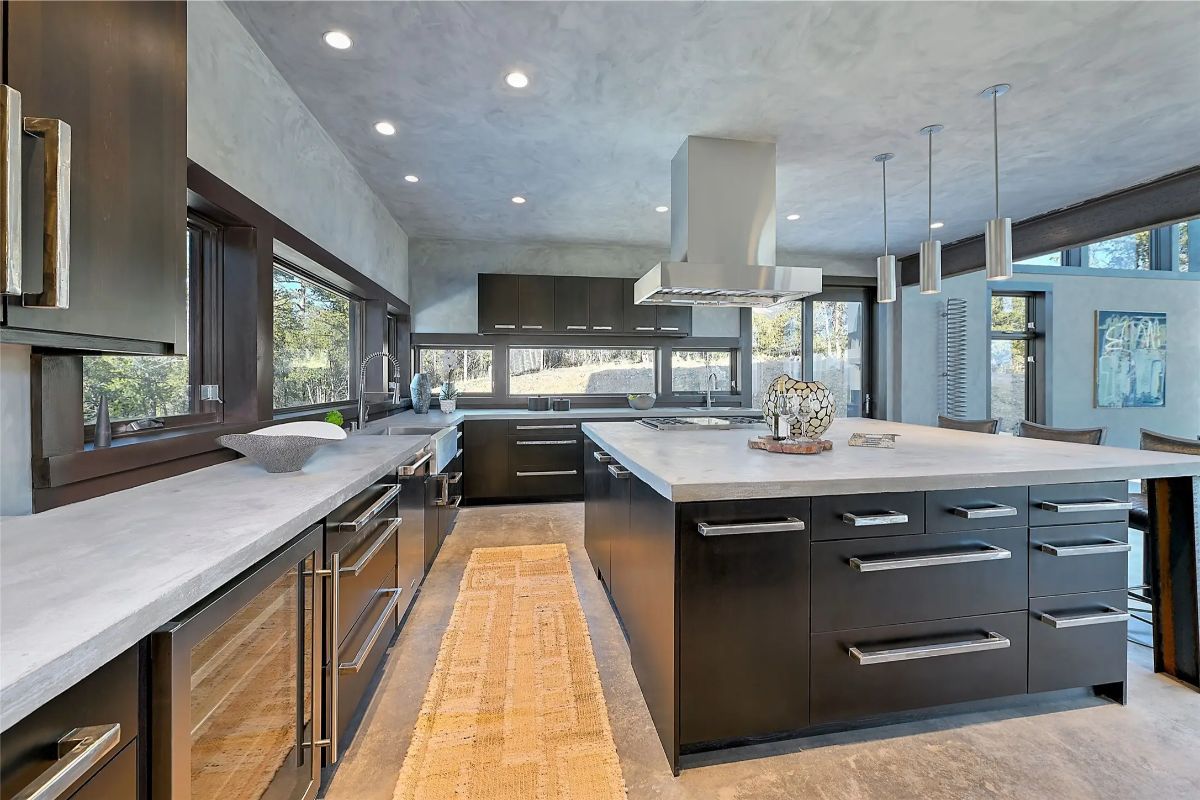 Sleek kitchen with double islands, dark cabinetry, and high-end appliances. 
