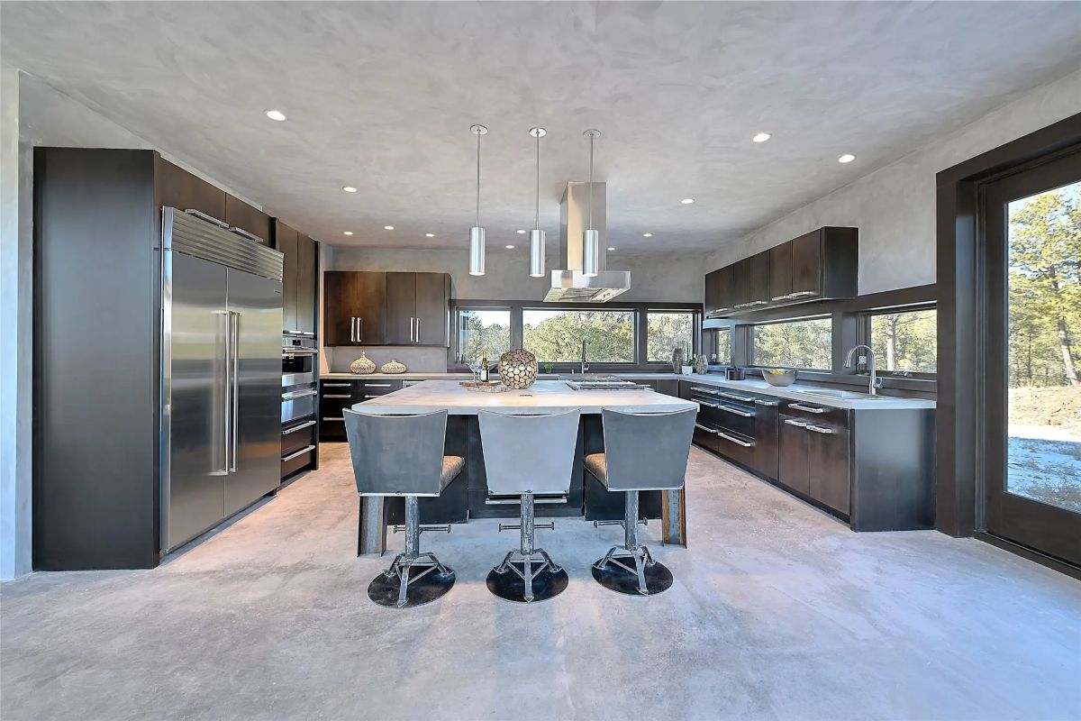 Alternate kitchen view with pendant lights, breakfast bar, and integrated wine fridge. 