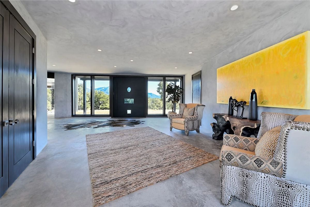 Entry hall with textured walls, neutral furnishings, and bold yellow artwork. 