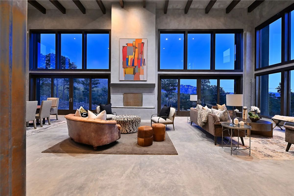 Open-concept great room with exposed beams, fireplace, and colorful abstract art. 