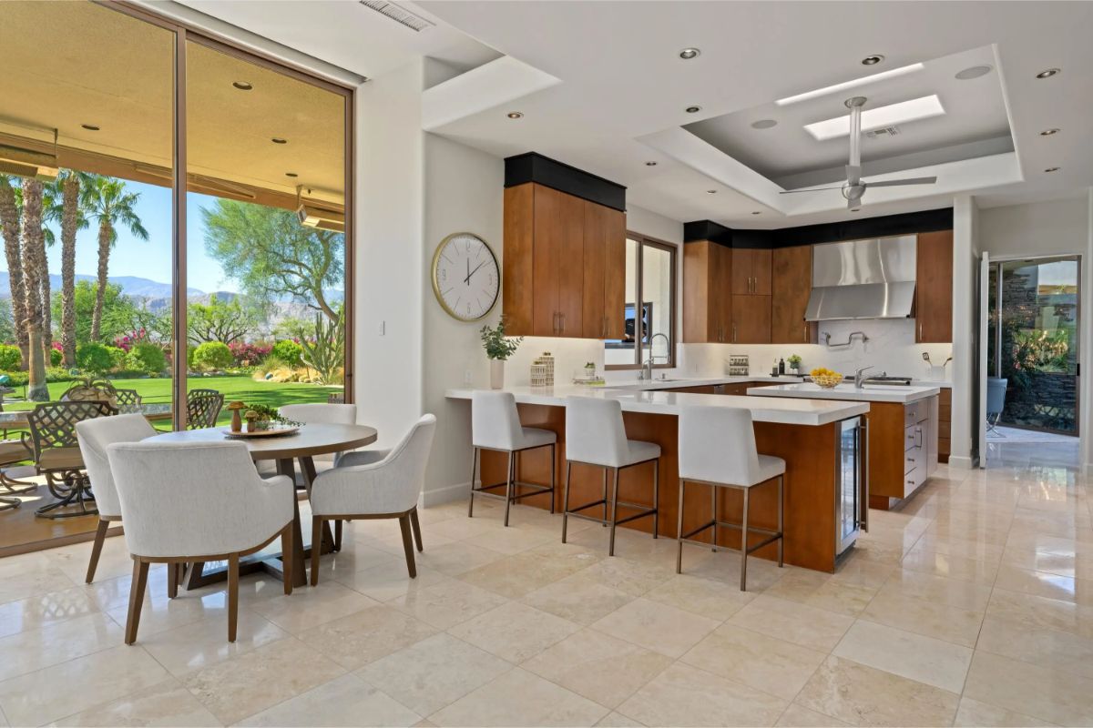 Bright kitchen and dining space with island seating and access to the backyard through sliding doors. 