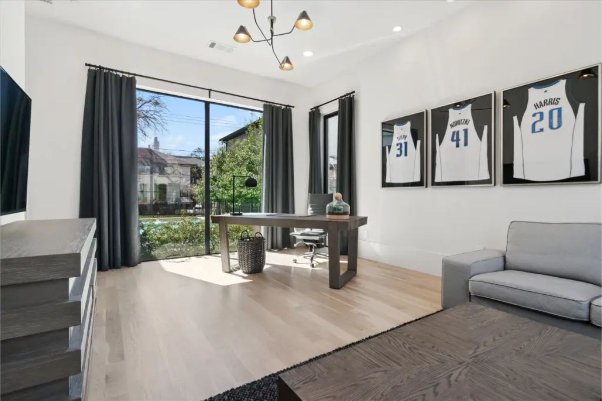 Reverse view of office showing desk facing glass doors and front yard. 