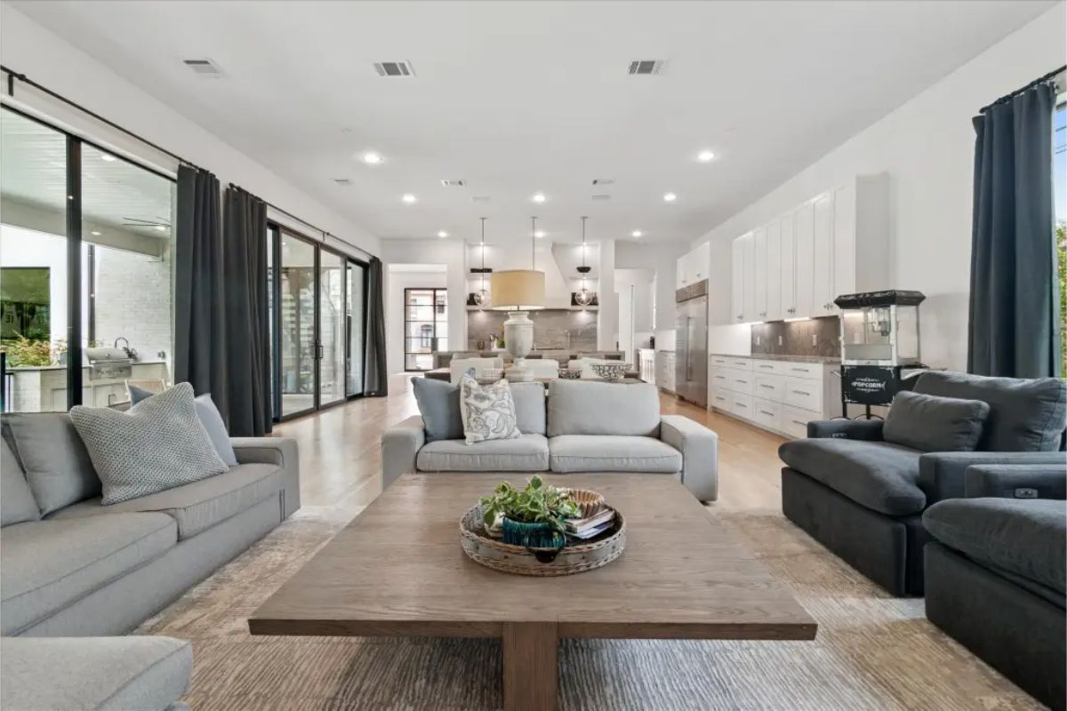 Open-concept living room and kitchen with sliding glass doors and recessed lighting. 