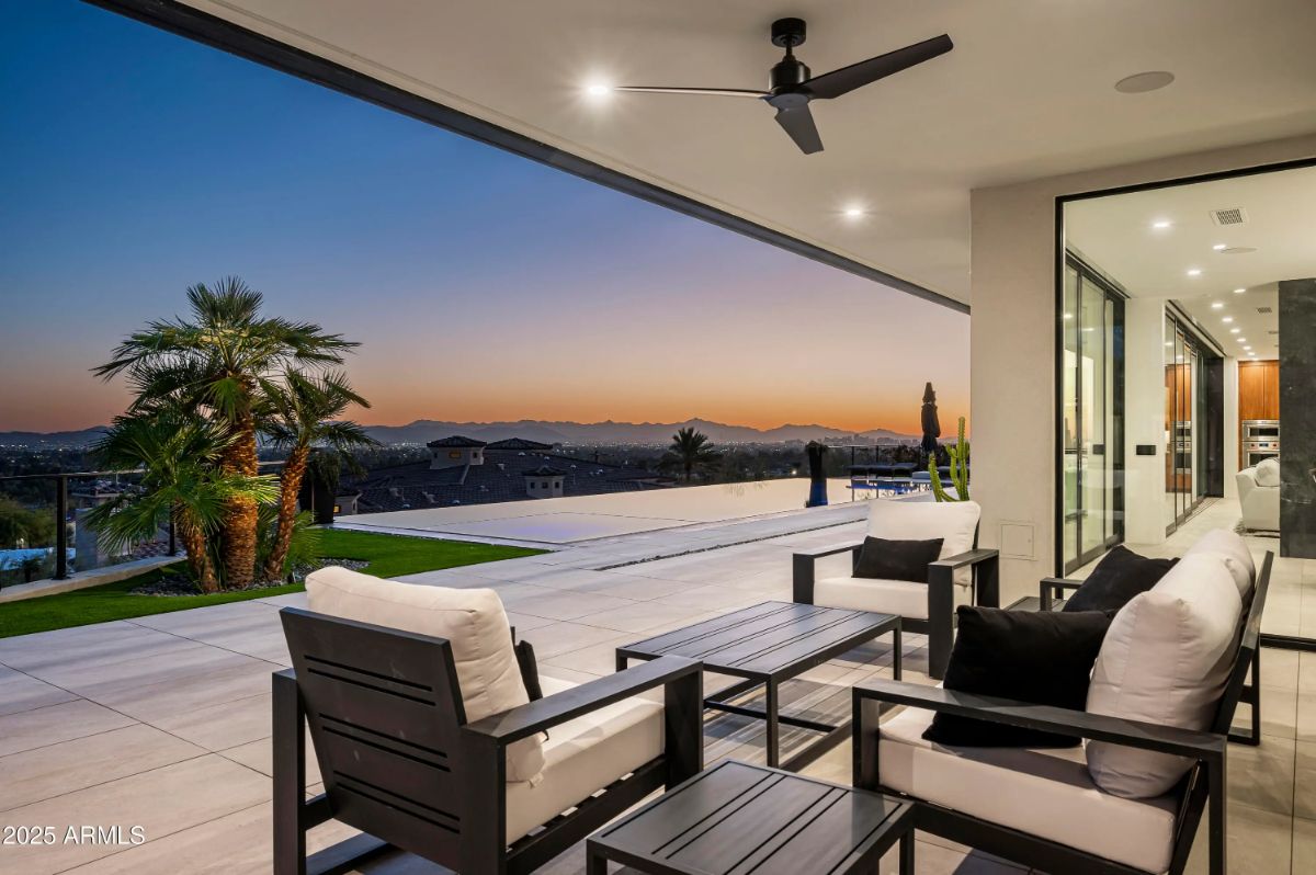 Covered patio with cushioned seating and expansive sunset views. 