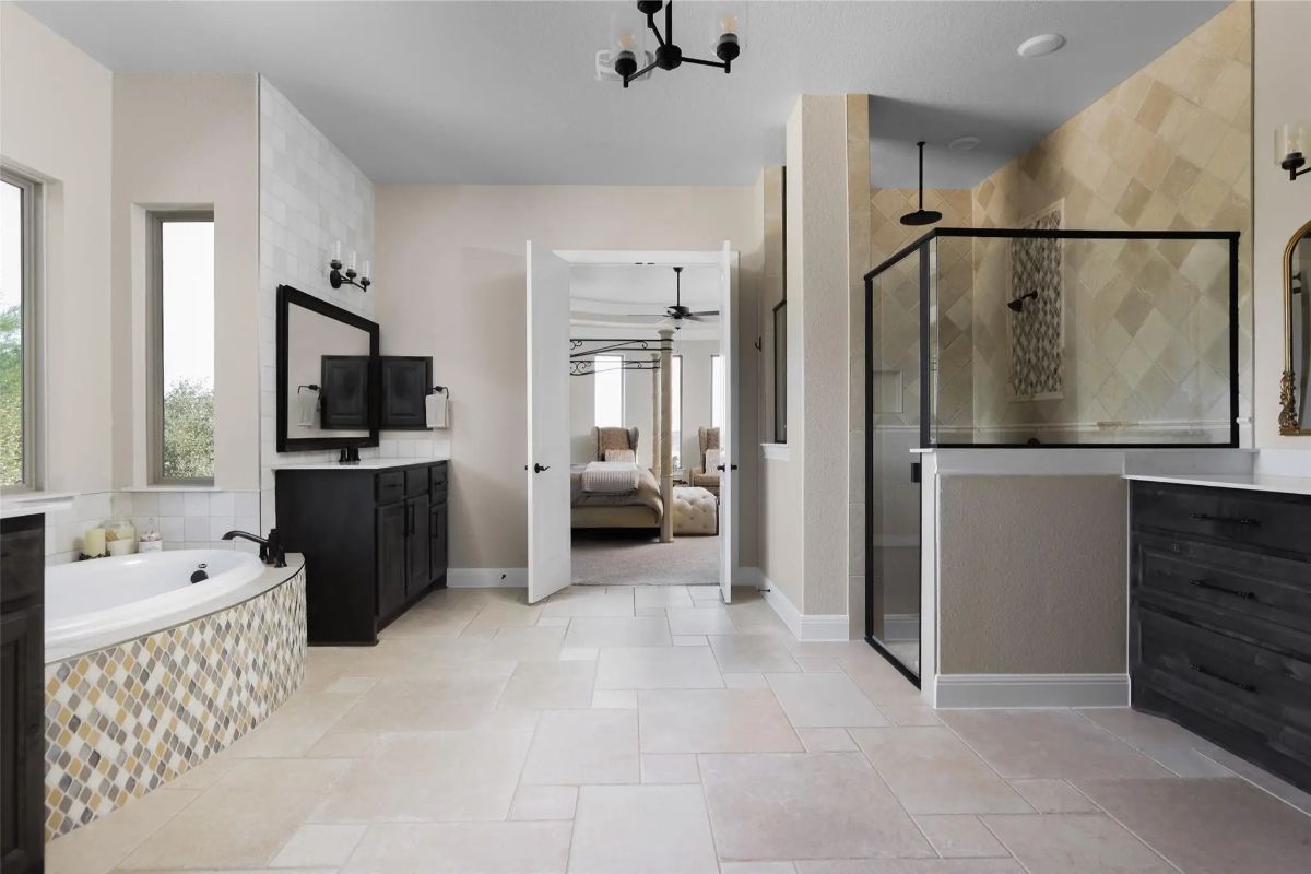 Glass-enclosed walk-in shower sits beside dark wood cabinetry.